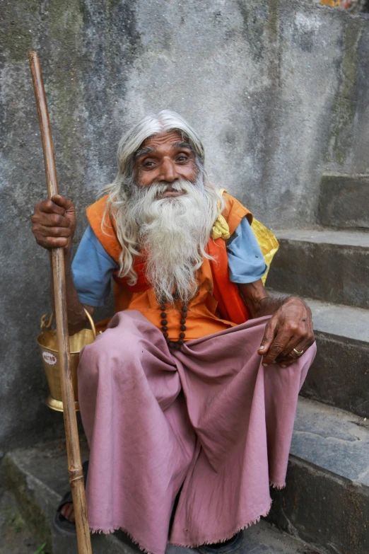 a man is sitting on steps with a stick