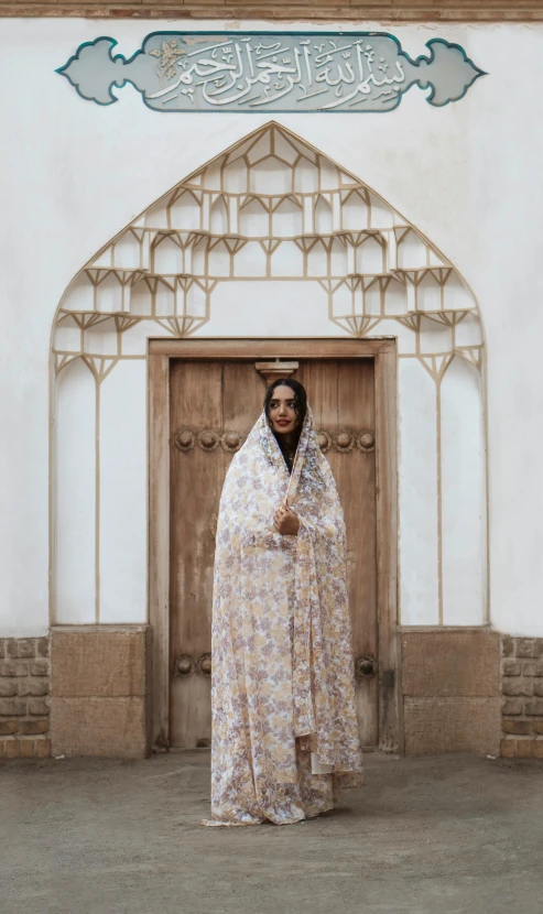 an oriental woman dressed in floral clothing stands on the sidewalk