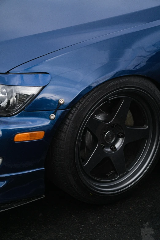 the front end of a blue car on a street