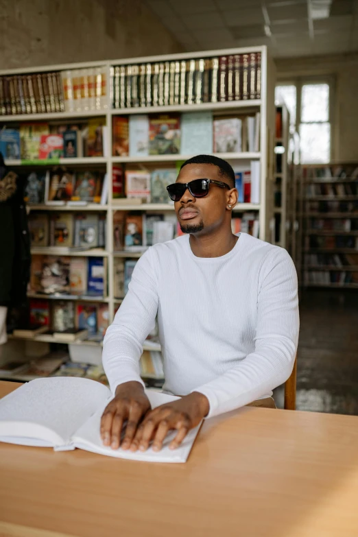 the man sits at a table in front of a book