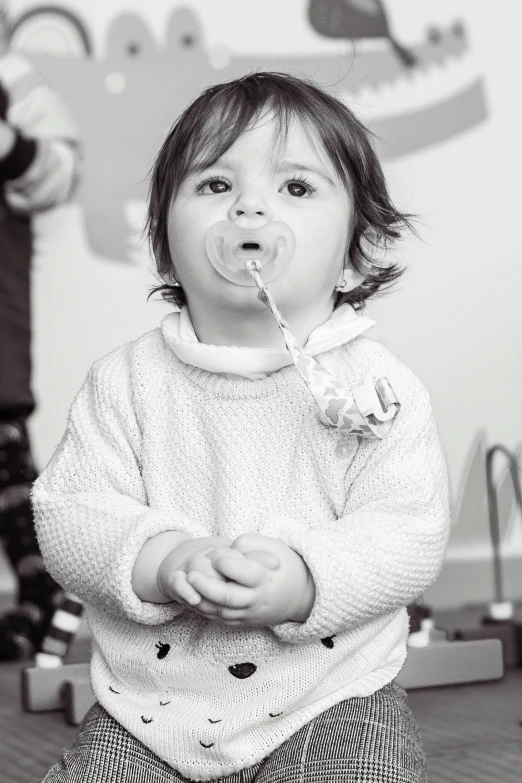 a  blowing on a toothbrush in her mouth