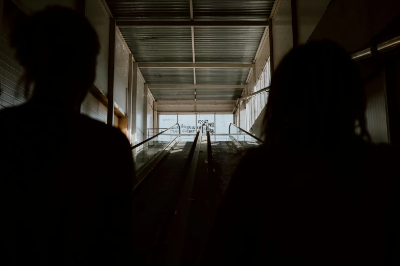 two people standing on the side of a ramp near one another