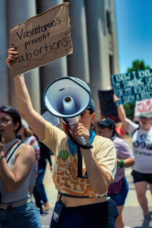 a man is holding a bullhorn sign in front of the crowd