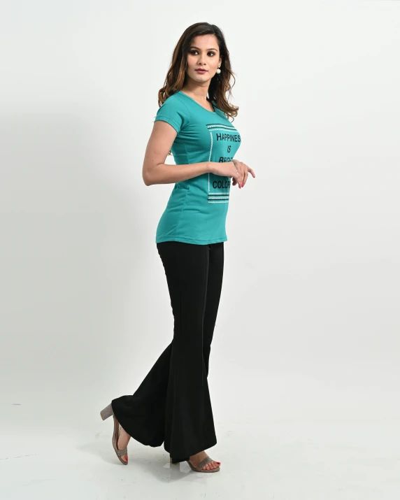 a women in a teal shirt standing up with one hand on her hip