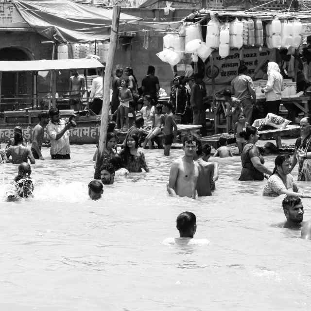 a group of people standing in the water in front of a shop