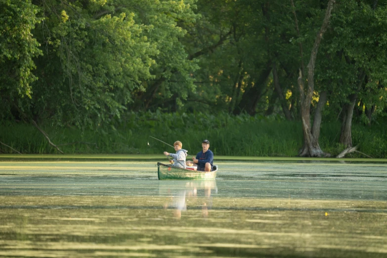 two people sitting in the middle of a river