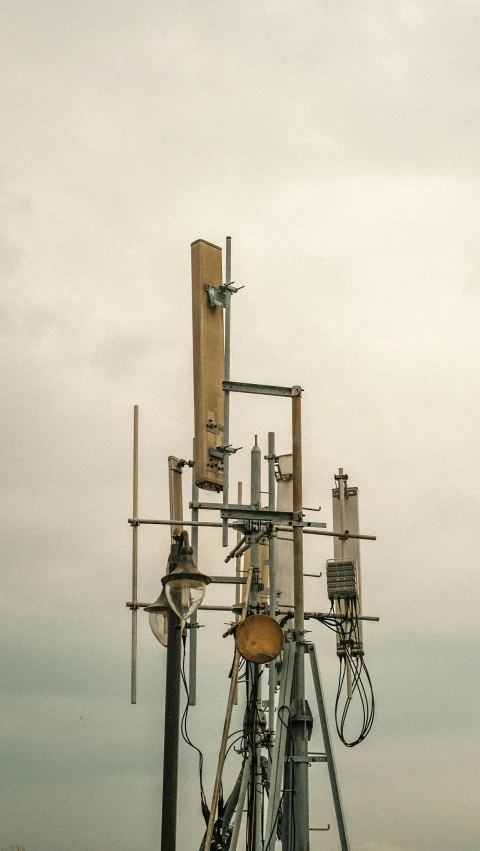 a cell tower with telephone poles and a sky background