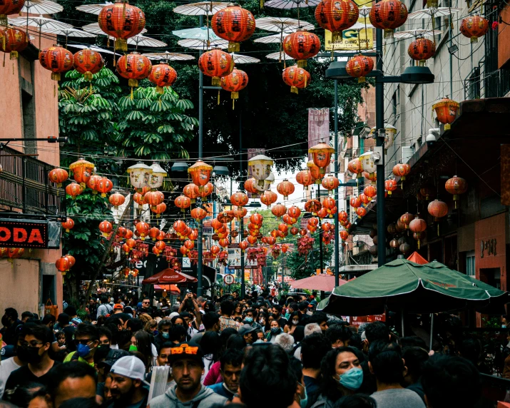 many people walk in front of some shops on a busy street