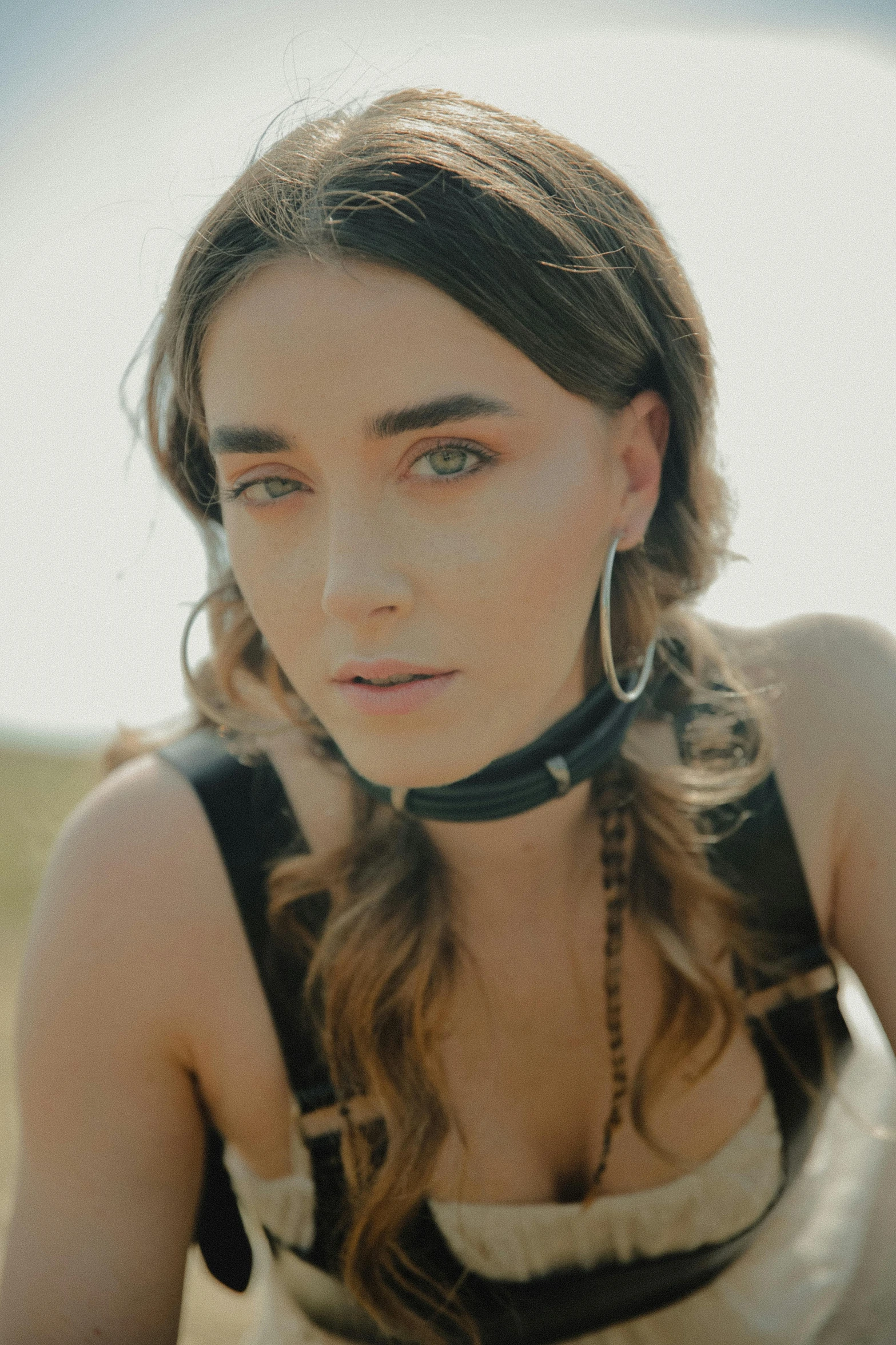 a young woman in an oversize top posing with a neck chain around her neck