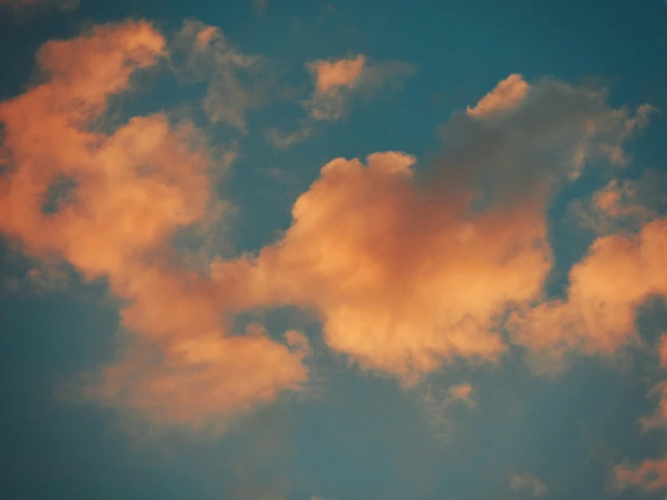 a plane flying high in the sky, with clouds