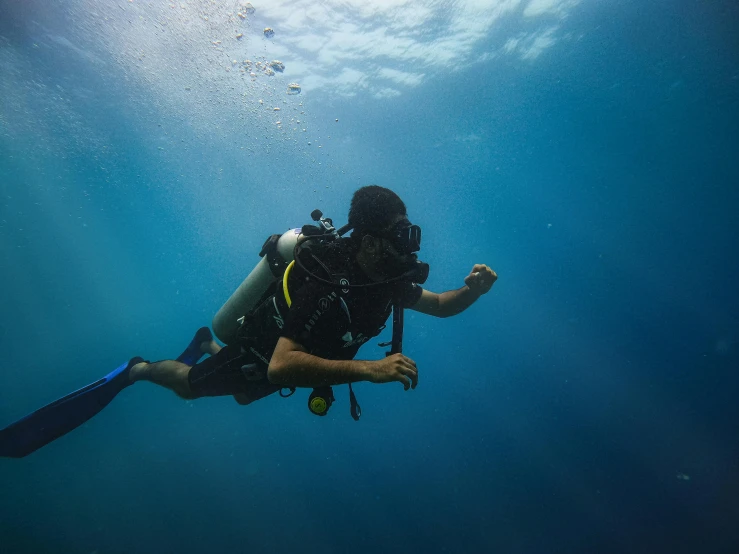 a man swims in the water with a backpack