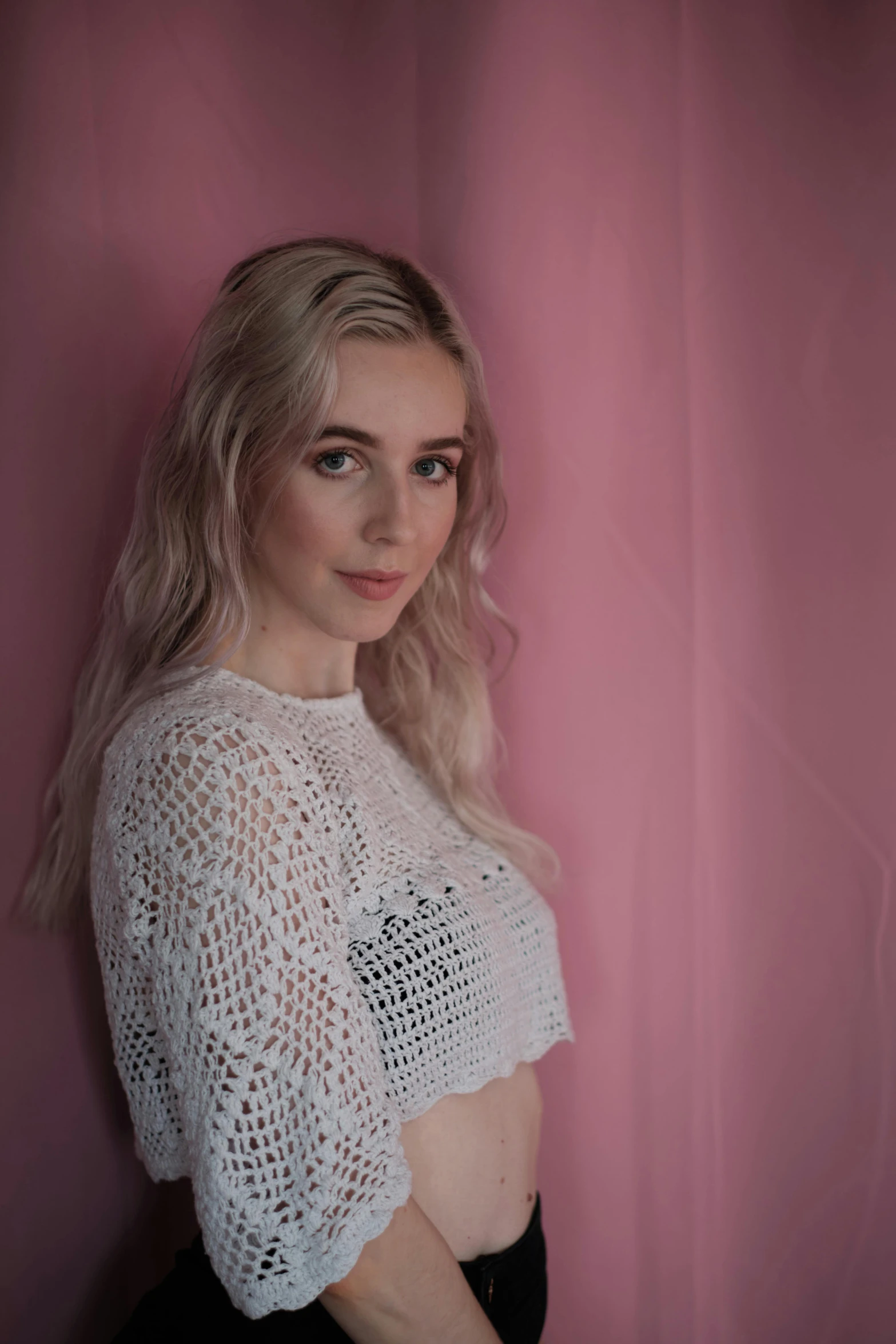 a young woman standing up against a wall