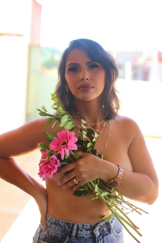 a young woman holding flowers near her stomach