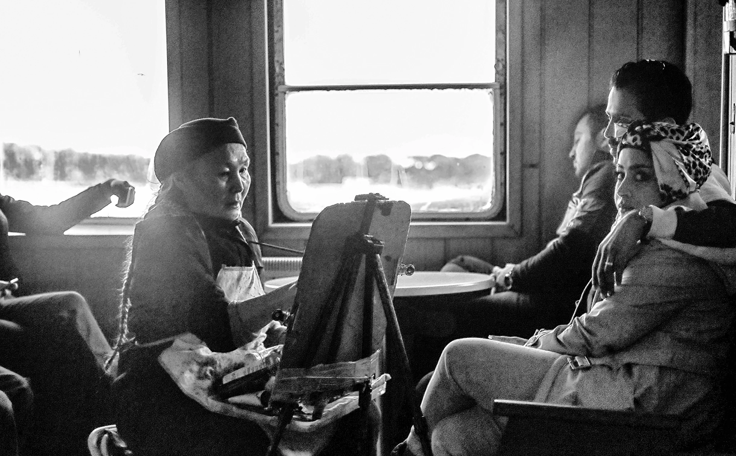 black and white pograph of people sitting at a table in a restaurant