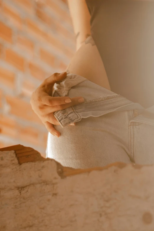 a pregnant woman's hand is holding on to her waist