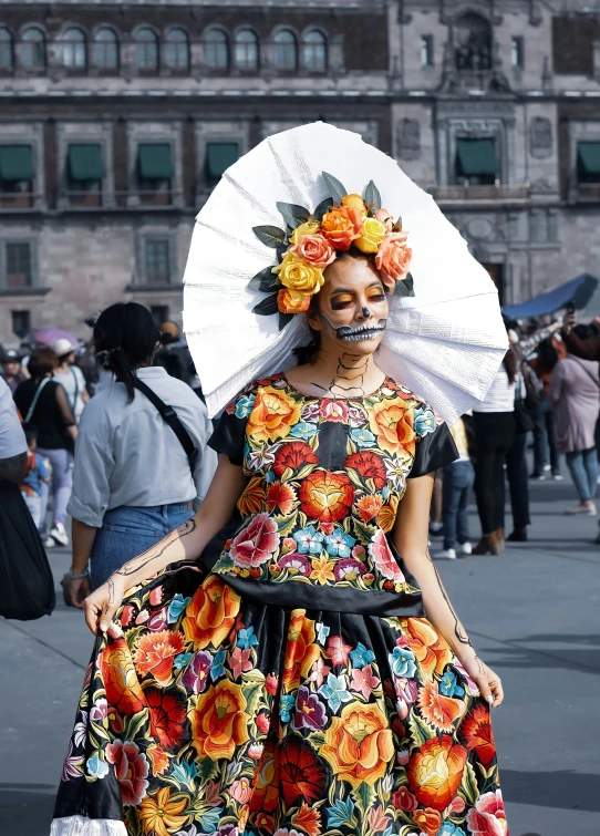 a woman dressed in colorful flowers holds an umbrella