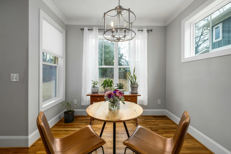 a table with two chairs sitting under a window