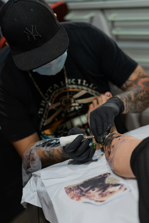 the tattooed man has his hand being done