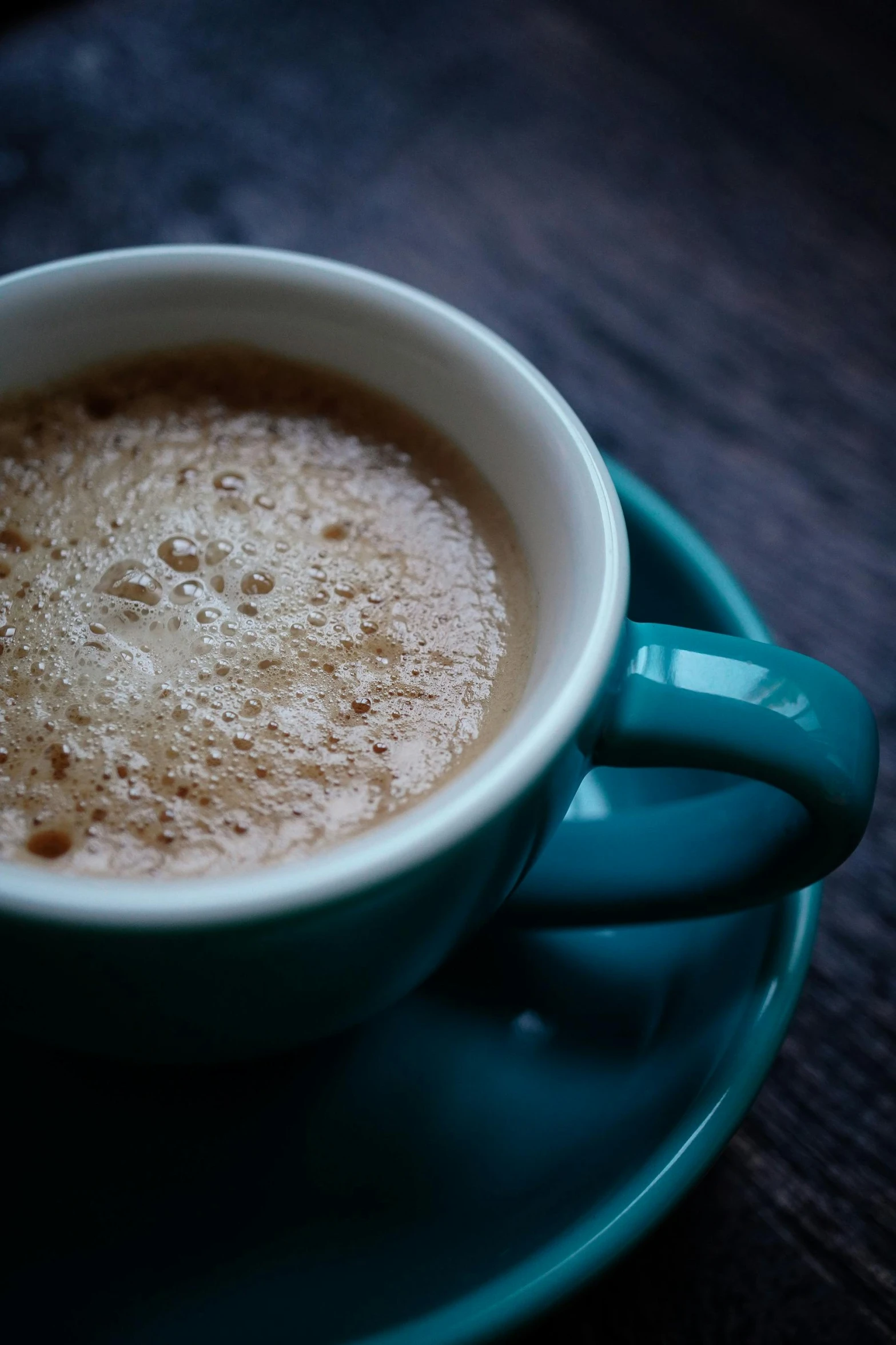 a cup with the foam on it, sits on a plate