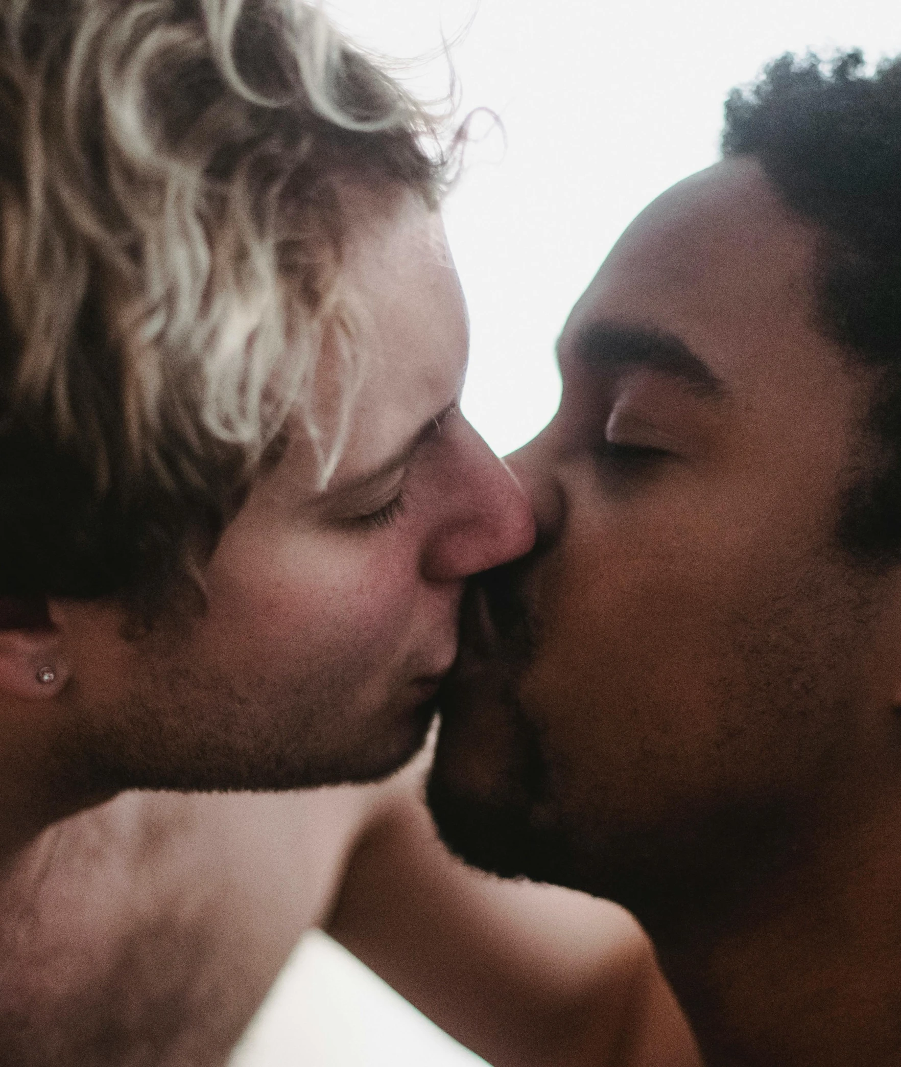 two guys kissing each other while one kisses his wife