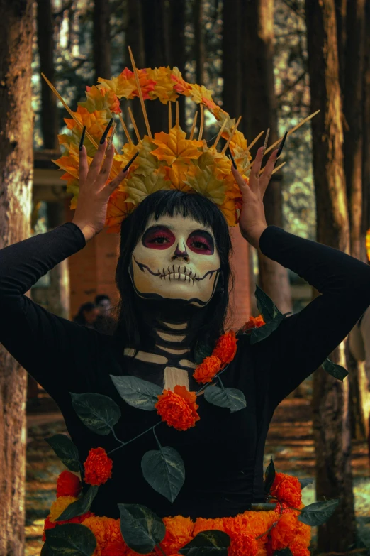 a woman dressed up in a skeleton costume, holding her hands up to her face