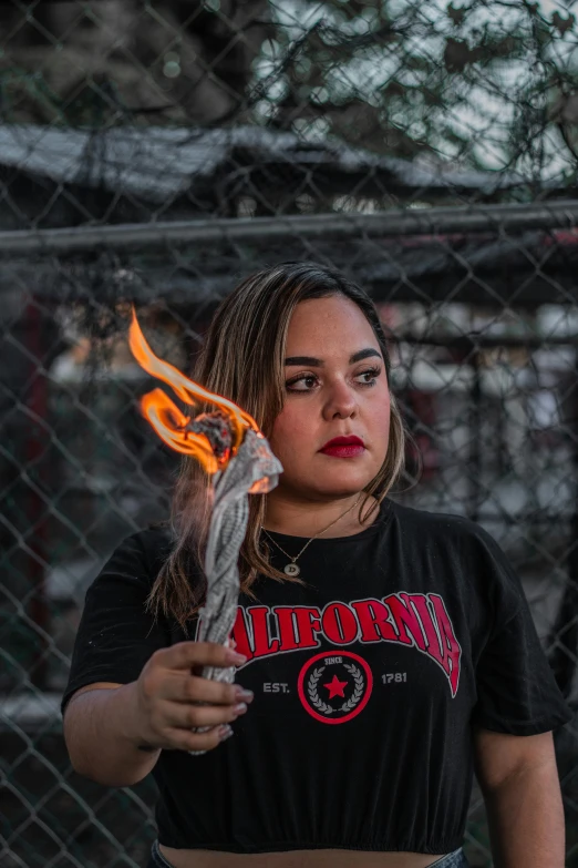 a young woman holding a piece of metal and burning it