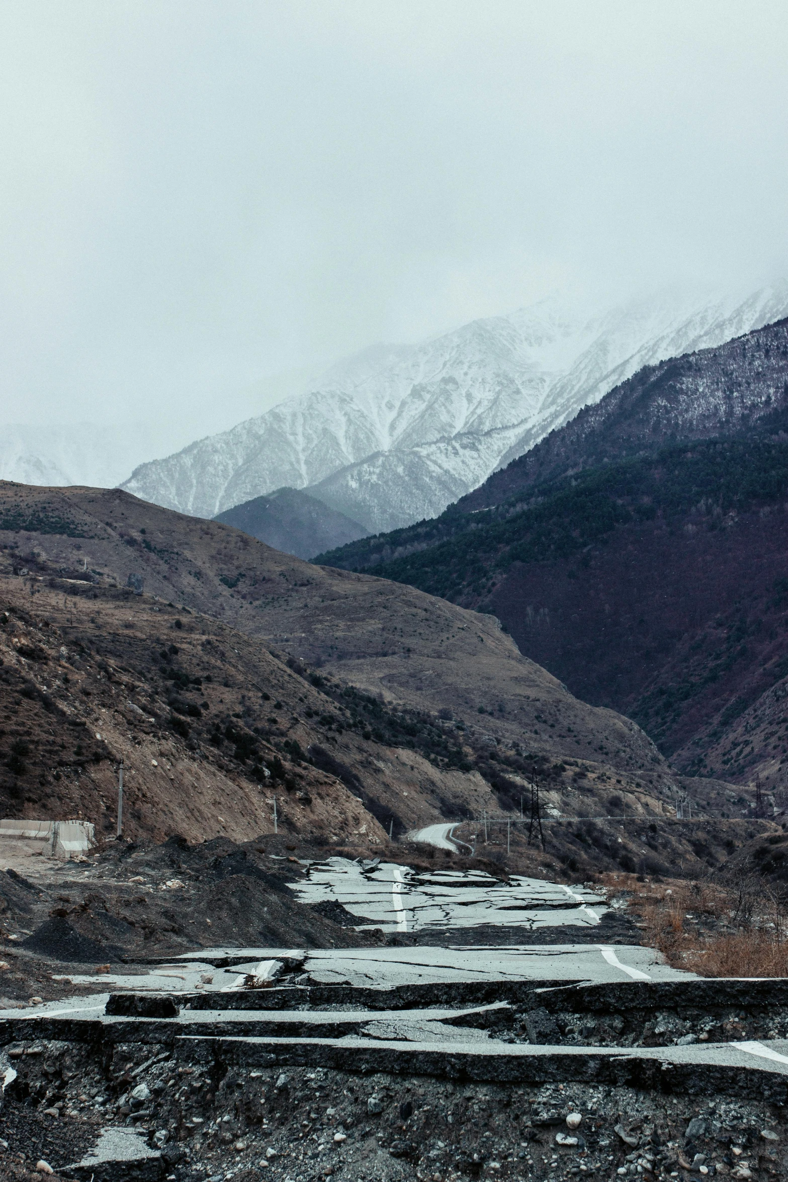 a snowy mountain valley with trees, water and rocks