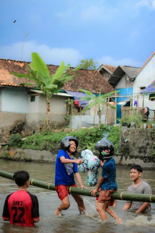 children play with the soccer ball in the water