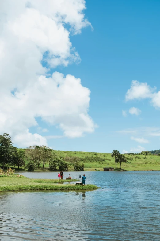 two people walking in front of a lake near trees