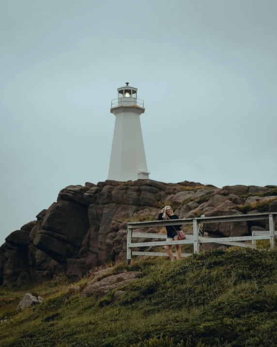 a couple of people stand near a light house