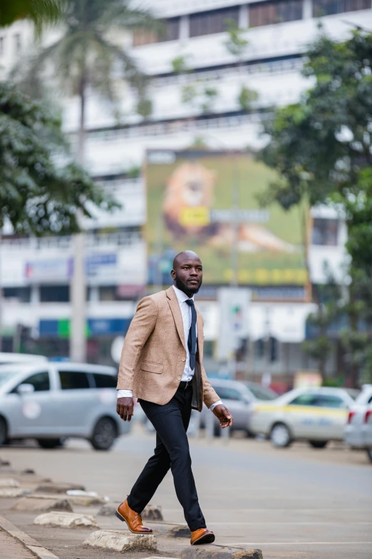 a man is wearing a blazer and walking across the street