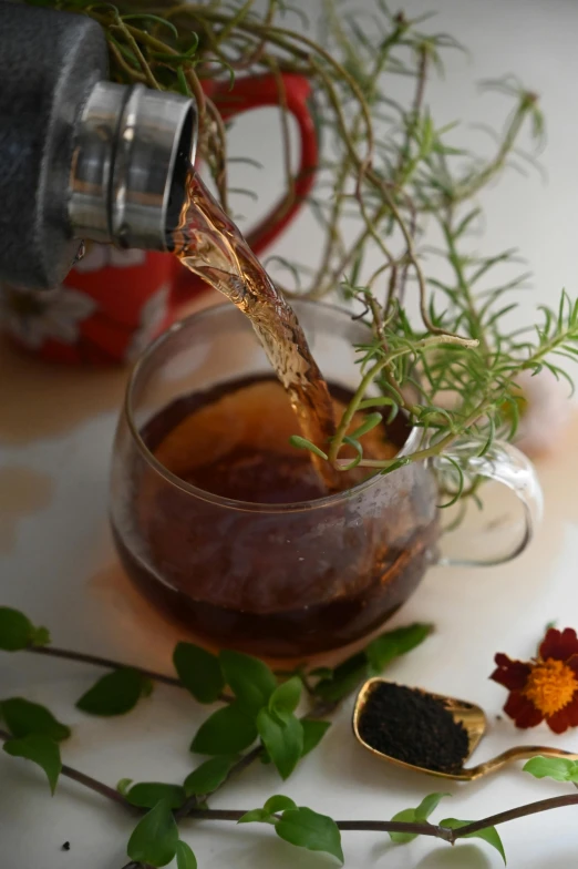 the glass is filled with tea and a spoon sits beside it