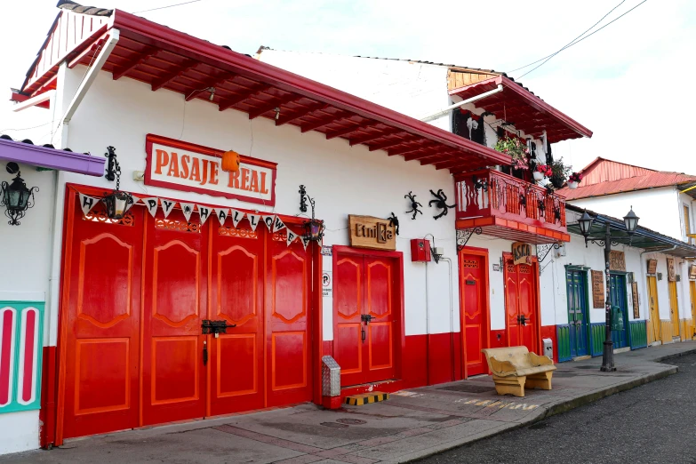 a row of red and white buildings with doors painted bright colored