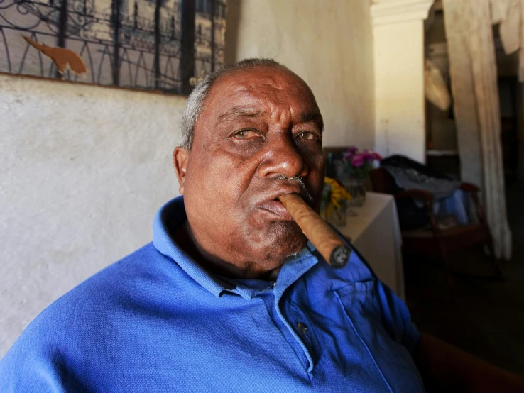 an older man smoking a cigar in his house