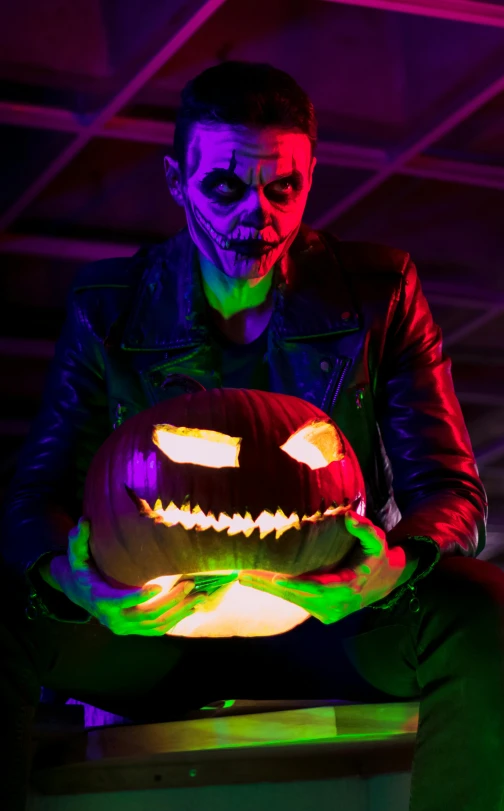 a person holding a large pumpkin that has been lit up