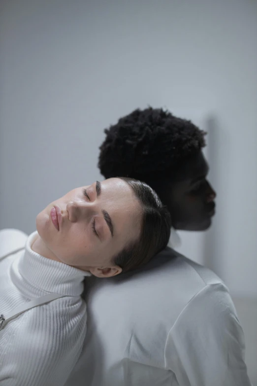 a person with their head next to a woman who has fallen asleep