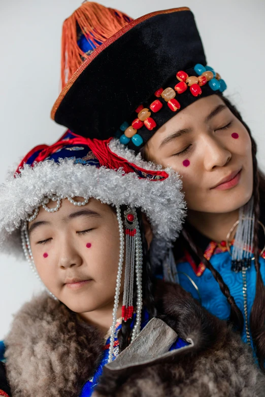 two children in native costumes that have beads on their heads