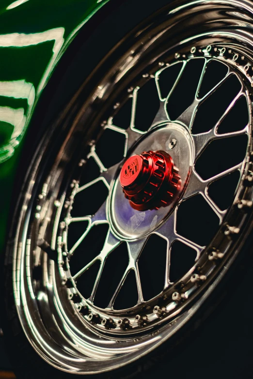 a chrome spoked wheel on a green racing car