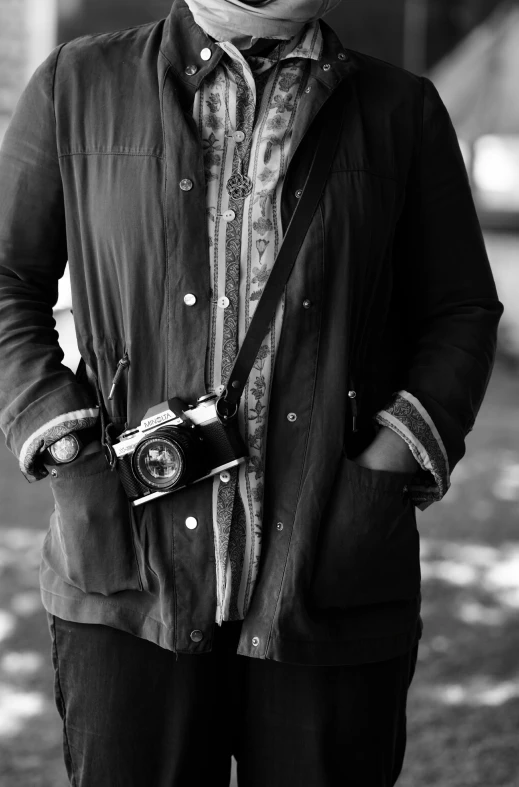 a woman with a hat and jacket is holding a camera