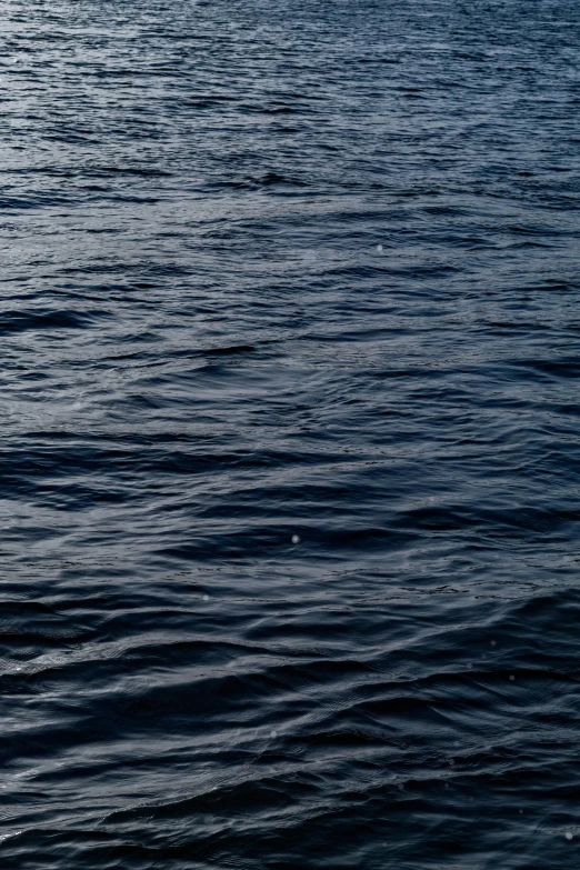 a very blue body of water with the boat and clouds