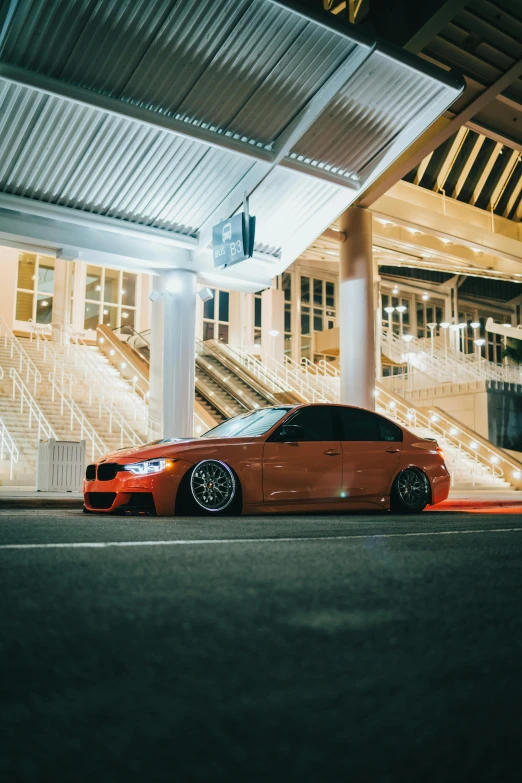 a bmw coupe sits parked on the side of a city street