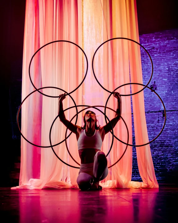 a person holding up three circular objects on a stage