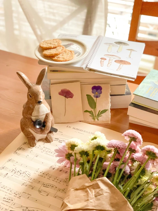 a rabbit figurine on a table with some flower