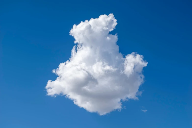 a very large cloud floating through a blue sky