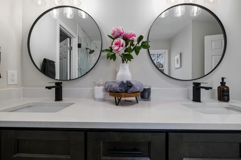 a large bathroom with three mirrors and two sinks