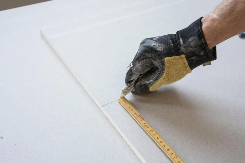 man in black gloves working on canvas