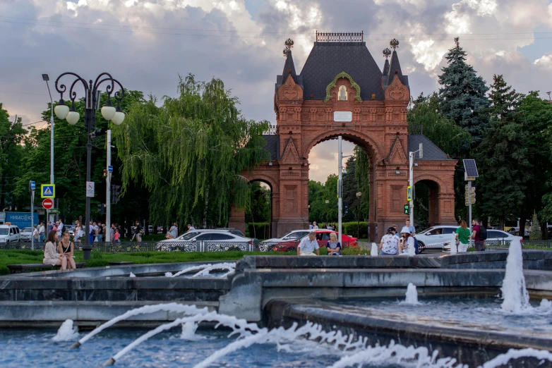 people are standing at an old looking fountain