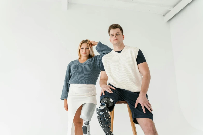 a woman and a man sitting on a chair with knee pads