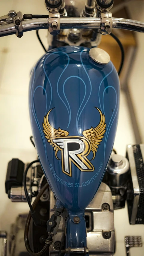 a blue motorcycle has gold emblem and wings