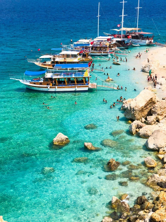 a long row of boats sitting on top of a blue sea